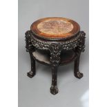 A CHINESE HARD WOOD JARDINIERE STAND, c.1900, the bead edged circular top inset with veined red