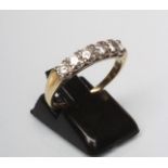 A SIX STONE DIAMOND HALF HOOP RING, the brilliant cut stones point set to reeded shouders and