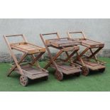 A SET OF THREE TEAK DRINKS TROLLEYS with removable slatted top tray, over fixed base tray with