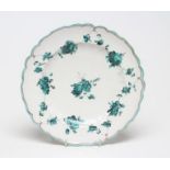 A CHELSEA PORCELAIN PLATE, c.1755, of fluted circular form, painted en camaieu green in the