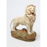 A ROYAL DUX BISQUE PORCELAIN LION, early 20th century, modelled standing on a rocky outcrop, pink