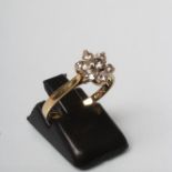 A DIAMOND CLUSTER RING, the seven round brilliant cut stones claw set in a flowerhead to a plain