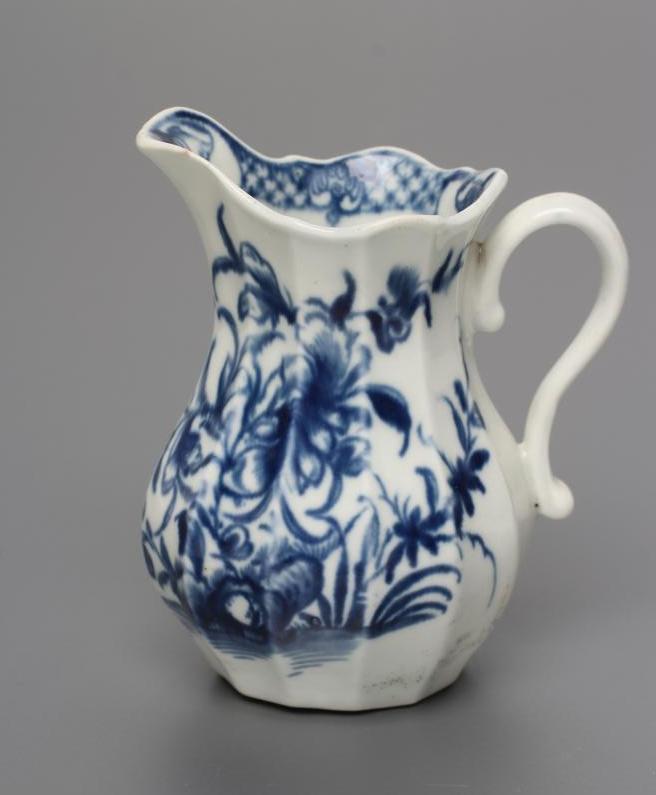 A FIRST PERIOD WORCESTER PORCELAIN MILK JUG, c.1760, of faceted baluster form painted in