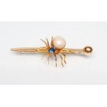 AN EDWARDIAN SPIDER BROOCH with oval facet cut sapphire head and blister pearl body on arrow head