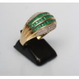 AN EMERALD AND DIAMOND COCKTAIL RING, the three rows of channel set square cut emeralds within