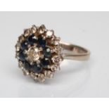 A SAPPHIRE AND DIAMOND CLUSTER RING, the central diamond claw set to a border of eight facet cut