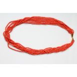 AN EIGHT STRAND CORAL BEAD NECKLACE on unmarked gold bow clasp, 32" long, including clasp (Est. plus
