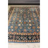 AN INDO PERSIAN CARPET, modern, the light blue field with repeating floral pattern in salmon pink,