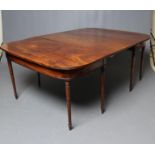 A GEORGIAN MAHOGANY EXTENDING DINING TABLE, c.1800, comprising a pair of D ends and central leaf,
