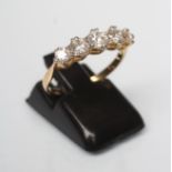 A FIVE STONE DIAMOND RING, the graduated brilliant cut stones claw set to a plain shank stamped