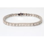 A MOISSANITE TENNIS BRACELET, the thirty six round brilliant cut stones point set in square panels
