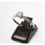 A SOLITAIRE DIAMOND RING, the round brilliant cut stone claw set to shoulders each point set with