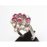 A RUBY AND DIAMOND COCKTAIL RING, the open starburst claw set with six facet cut rubies and twelve