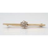 A DIAMOND TIE PIN, the unmarked knife edge bar centred by a seven stone point set cluster, 1 1/2"