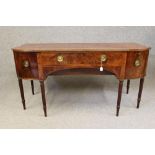 A GEORGIAN MAHOGANY SIDEBOARD, c.1800, of bowed breakfront form with brass trim and stringing,
