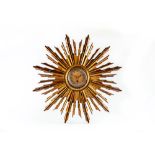 A FRENCH CARVED AND GILT WOOD SUNBURST WALL TIMEPIECE, early 20th century, the single barrel