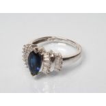 A SAPPHIRE AND DIAMOND DRESS RING, the central marquise cut sapphire set to double fan shoulders