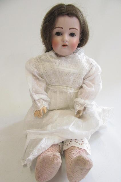 A Kestner bisque shoulder head doll with brown glass sleeping eyes, open mouth with four top