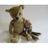 An old teddy, with amber coloured eyes, sewn nose, fabric pads and rotating joints, 20", together