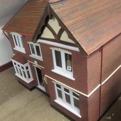 A doll's house, mid 20th century, painted wood construction with gabled roof, two storey three bayed