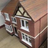 A doll's house, mid 20th century, painted wood construction with gabled roof, two storey three bayed