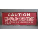 A large wooden warning sign, painted in red and white with the following inscription "CAUTION