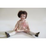 A small German all bisque character doll, with blue glass eyes, brown wig, bent arms, straight legs,