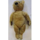 An English teddy bear, mid 20th century, in gold plush with black/amber eyes, swivel joints, growl