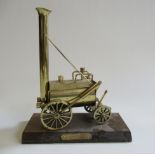 A brass stationary model of Stephenson's Rocket on wooden base with name plate, G (Est. plus 21%