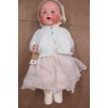 An Armand Marseille bisque socket head baby doll with fixed blue glass eyes and open mouth,
