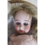 An Armand Marseille 1894 bisque socket head doll, with blue glass sleeping eyes, open mouth with