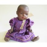 A Heubach bisque socket head mulatto baby doll, with brown glass sleeping eyes, moulded hair, bent