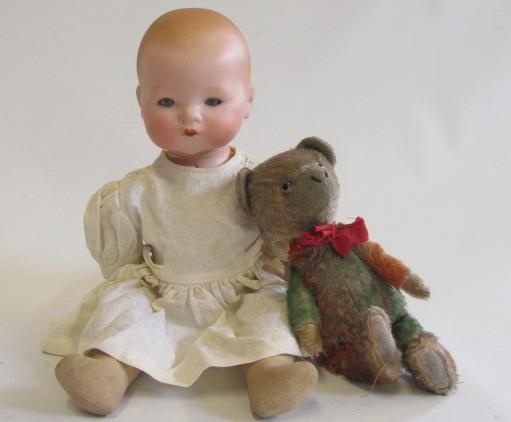 An Armand Marseille bisque flange neck baby doll with blue glass sleeping eyes, closed mouth, fabric