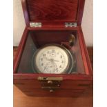 A brass ships clock mounted on gimbal in mahogany case. (From a Russian submarine).