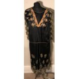 A black silk 1920/30s dress with long decorative lace sleeves with orange, green and yellow