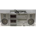 A 1980's Amstrad ghetto blaster with two speakers. Radio Cassette model 8090 with 2 detachable