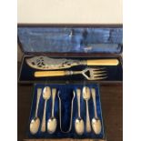 Boxed silver spoons and plated fish servers.