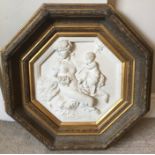 A large gilded hexagonal framed white marble effect relief plaque. 41.5cms.