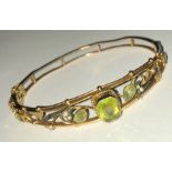 A 19thC hinged 9 ct gold bracelet with topaz and seed pearls. 9.3gms.
