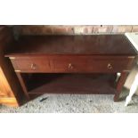 A dark wood and brass bound coffee table on square legs.