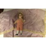 Early 20thC bisque doll in pink woollen suit & hat with silk lace edges handkerchief. 11.5cms h.
