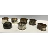 Seven assorted hallmarked silver napkin rings, approx 187 gms.