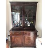 A 19th century glazed bookcase on cupboard base. 125cms w x 60cms d x 215cms h.