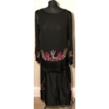 A 1920's black silk dress with long sleeves, covered buttons decorated with pink, blue, lilac and