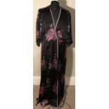 A long black button front gown with floral pattern.