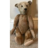A straw filled plush fur humpback teddy bear, well loved, approx 50cms h.