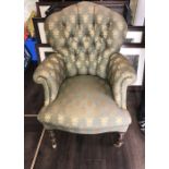 Well upholstered armchair on turned front legs with brass castors. Green Fleur de lys upholstery.
