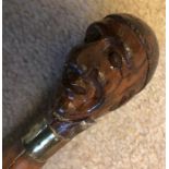 A 19thC walking cane with a carved wooden head believed to be a famous Berverlonian.