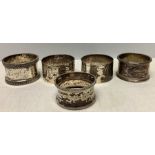 Four silver hallmarked napkin rings plus one white metal (marks rubbed) total weight of 4, 119.