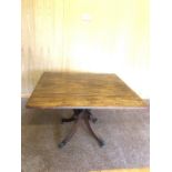 A mahogany pedestal table, 105 x 112cms leaves extended, brass lions paw feet.